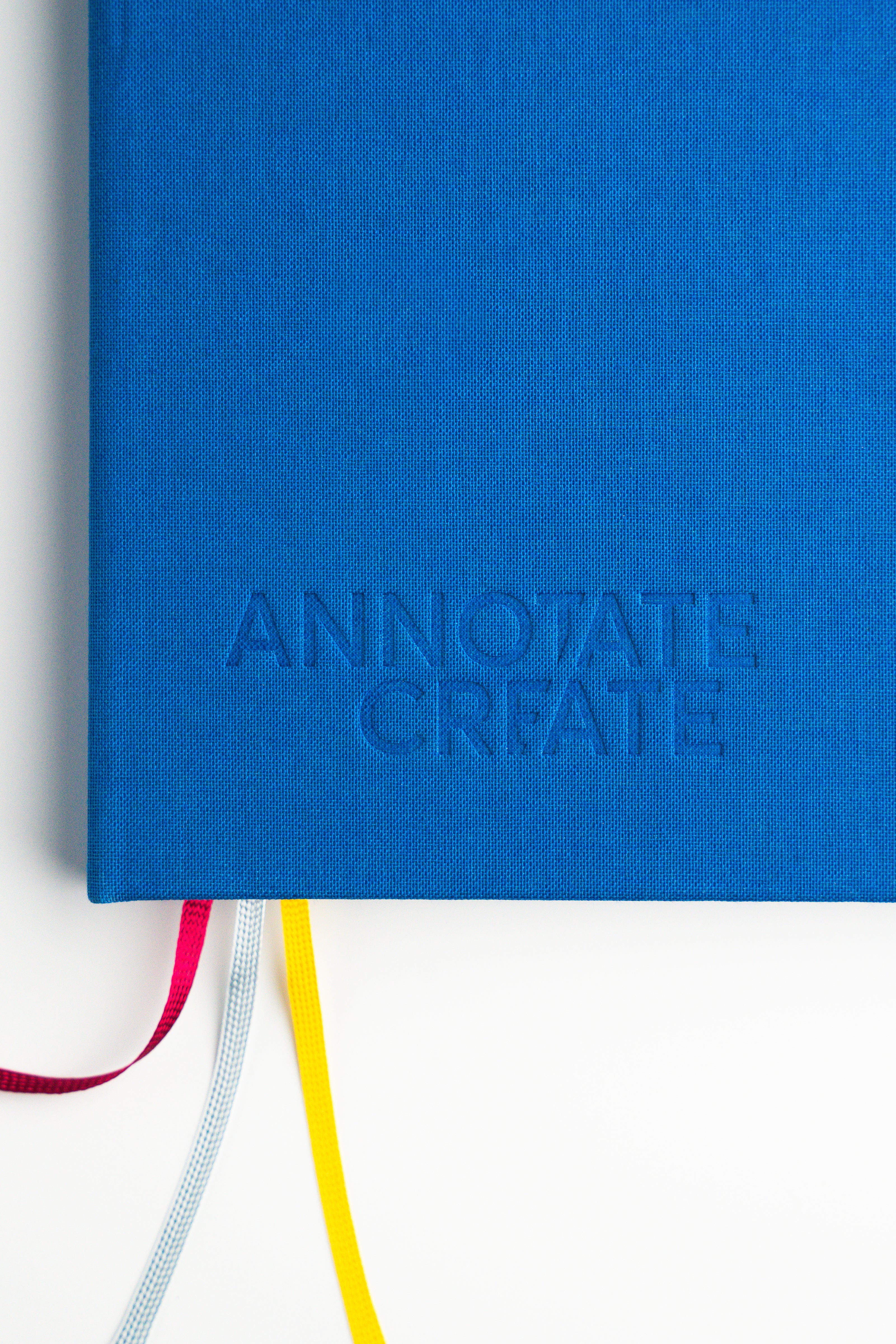 Close-up of Nōto notebook's embossed blue fabric cover showing the brand logo