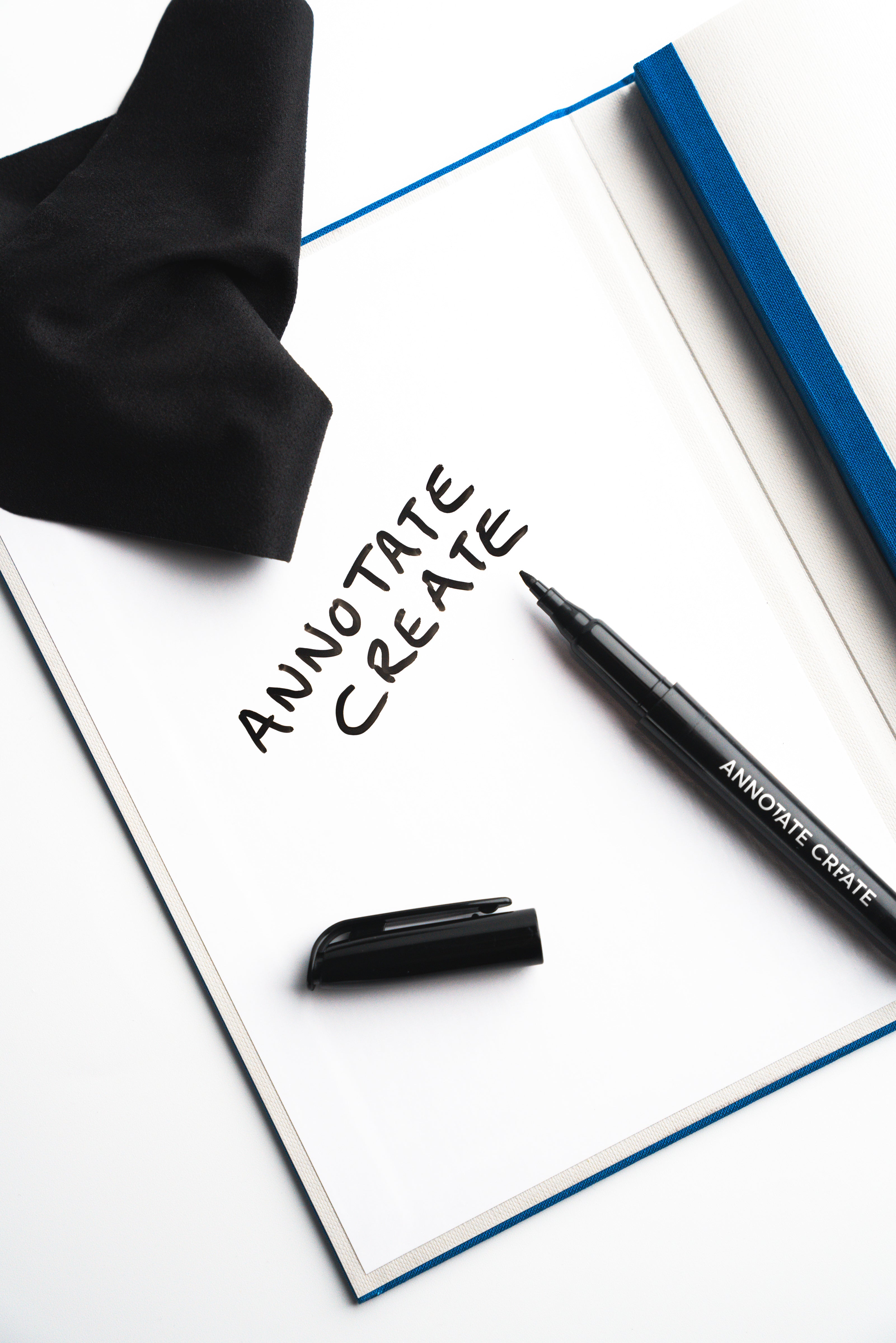 Whiteboard marker resting on Nōto notebook's built-in whiteboard page with black cloth pouch